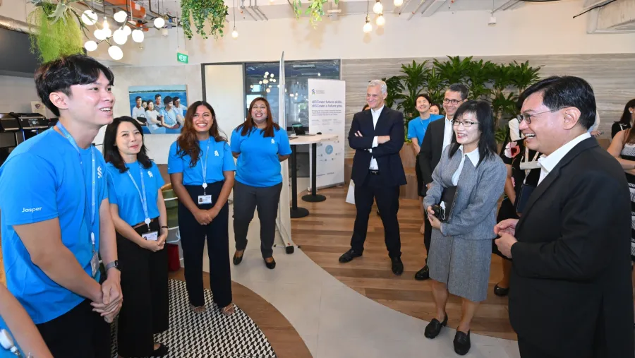 Deputy Prime Minister and Coordinating Minister for Economic Policies Heng Swee Keat speaking with some Standard Chartered Bank employees who have benefitted from the Bank’s upskilling and reskilling programmes.