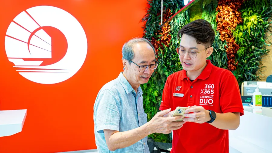Longtime customer Mr Albert Lam learns what precautions he can take to avoid falling victim to fraudulent transactions and scams from digital ambassador Deon Khng at workshop conducted at Tampines branch on 16 April 2023 (Photo courtesy of OCBC)