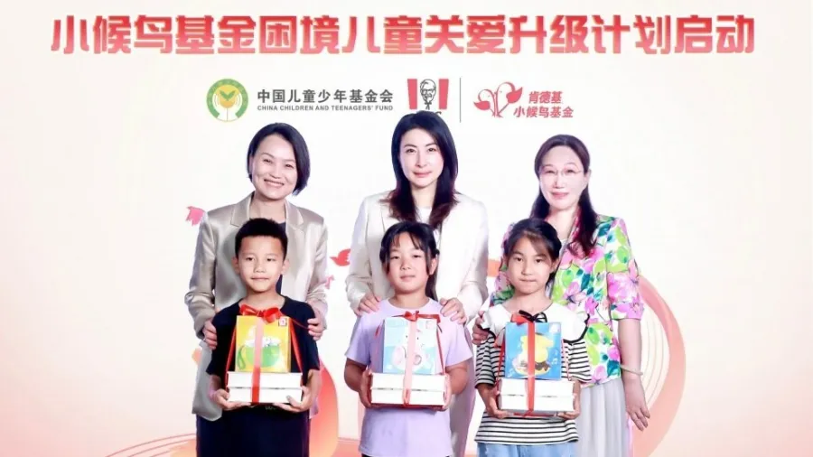 Joey Wat, CEO of Yum China, Zhu Dongyun, Deputy Secretary-General of the China Children and Teenagers' Fund, and KFC China’s first Goodwill Ambassador, Olympic Champion Guo Jingjing, share gift packages with “Little Migratory Bird” representatives /Yum China Holdings, Inc.