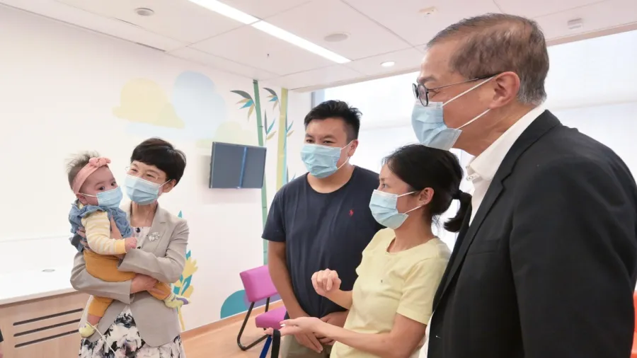 HK news government site: Healthy child: Secretary for Health Prof Lo Chung-mau (first right) and the National Health Commission’s Department of Medical Emergency Response Director-General Guo Yanhong (second left) visit a baby who last December received a donated heart.
