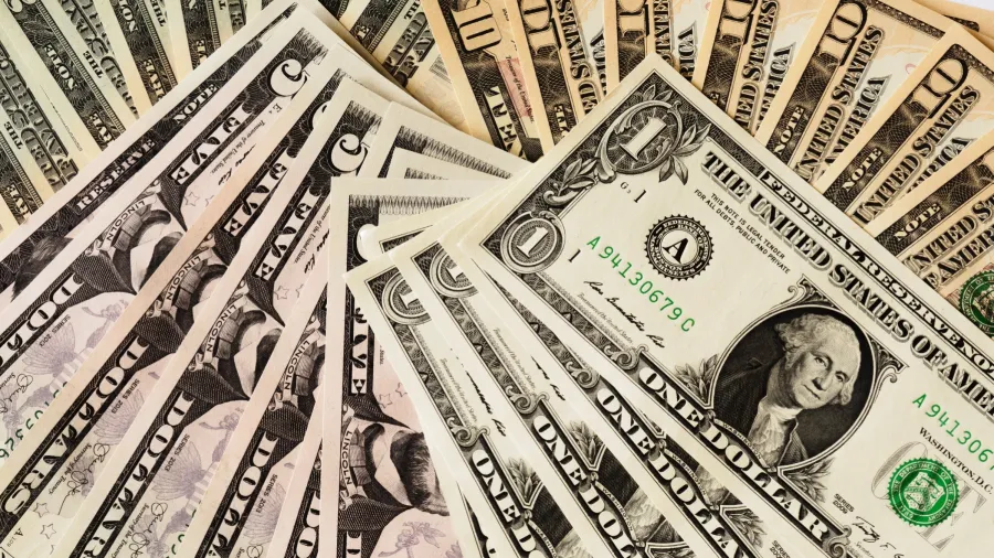 Dollar bills (Photo by Alexander Schimmeck via Unsplash)