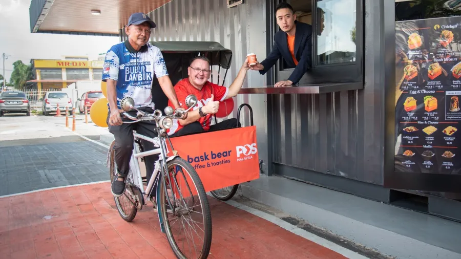 Bryan Loo (right), Founder and CEO of Loob Holding Sdn Bhd, serving the first symbolic cup of Bask Bear to Charles Brewer, Group CEO of Pos Malaysia Berhad. /Bask Bear Coffee