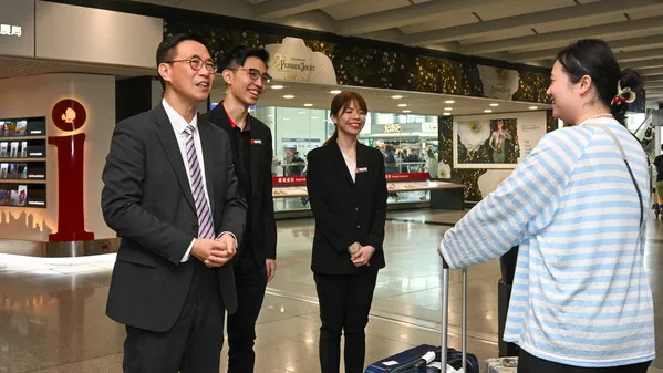 Secretary for Culture, Sports, and Tourism Kevin Yeung (first left) welcomes an independent visitor from the Mainland at Hong Kong International Airport. (Photo from news.gov.hk)
